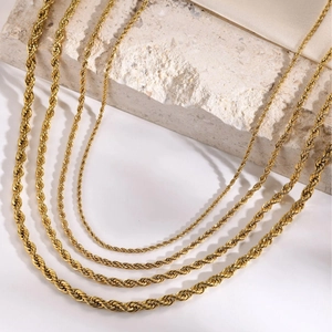 Gold plated stainless steel rope chains in various thicknesses on elegant fabric