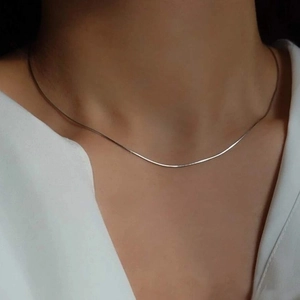 Collier chaîne serpent minimaliste en acier titane argenté porté sur cou féminin