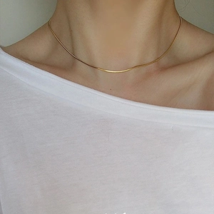 Élégant collier chaîne serpent dorée sur le cou pour un style minimaliste raffiné