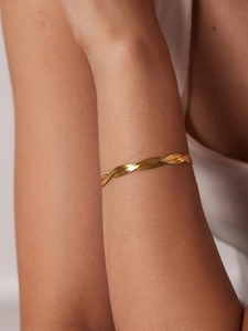 Detail of a gold plated double-layered braided snake chain bracelet on a woman's wrist