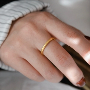 Dettaglio di un anello in acciaio inossidabile placcato oro opaco indossato al dito