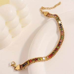 Macro di un bracciale in acciaio inossidabile dorato con pietre di zirconi colorati