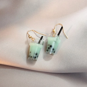Detail of miniature bubble tea earrings with gold hooks and green liquid resin
