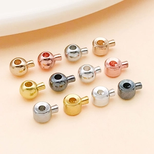 Macro detail of various copper crimp beads in assorted metallic finishes for DIY jewelry