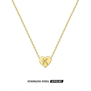Detailed view of golden stainless steel heart pendant with engraved letter K on O-chain