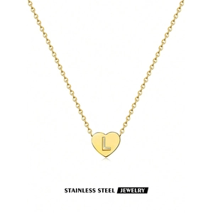 Detail of a gold stainless steel heart necklace featuring an engraved letter L pendant
