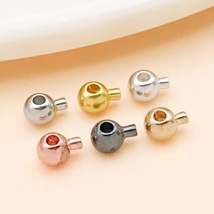 Macro detail of six metallic jewelry crimp beads in various finishes for DIY bracelets