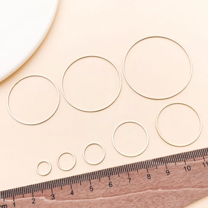 Multiple sizes of light gold brass geometric rings on a ruler for DIY jewelry making