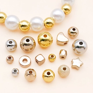 Draufsicht auf diverse goldene und silberne DIY-Perlen mit Sternen und Herzformen