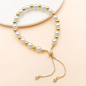 Detail of adjustable pearl and gold bead bracelet with crystal accents and bolo clasp