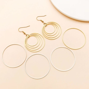 Detailed flat lay of geometric multi-layer copper hoop earrings and round DIY accessories