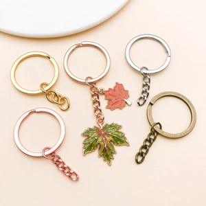 Five metallic keychains in gold, silver, and bronze finishes with enamel maple leaf pendants