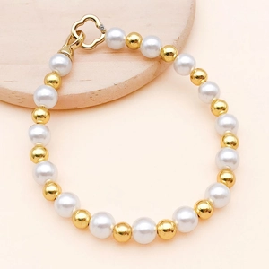 Detaillierte Makroansicht des goldfarbenen Blumenverschlusses am Perlenarmband