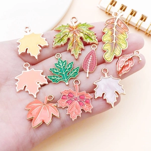 Detailed close-up of colorful enamel leaf charms including maple and oak patterns