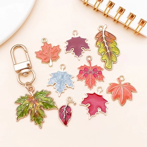 Close-up of colorful enamel maple leaf pendants and autumn leaf keychains for DIY jewelry
