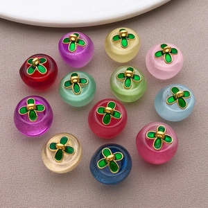 Macro shot of 12 colorful glass clover apple charms with golden leaf metal hooks