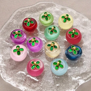 Macro shot of colorful glass clover apple pendants arranged on a textured glass tray