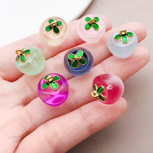 Macro detail of multi-colored glass persimmon pendants with green clover leaf charms