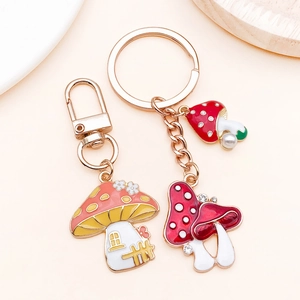 Detailed view of mushroom enamel charms in orange and red for DIY keychains and jewelry