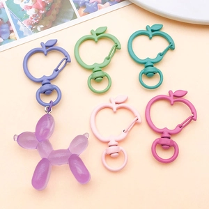 Detail of colorful apple-shaped alloy keychains with a purple balloon dog charm