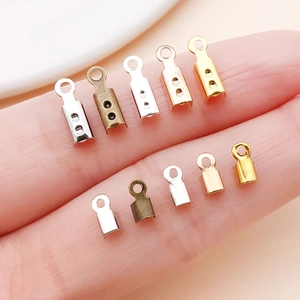 Five colors of iron cord end caps in different sizes held by hand for DIY jewelry making