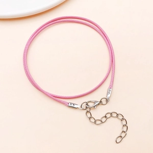 Detail of pink braided wax cord necklace with silver lobster clasp and extension chain