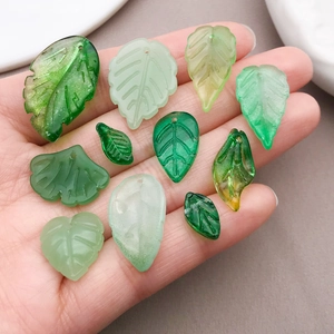 Detailed view of assorted green faux glass leaf pendants for DIY earring and jewelry making