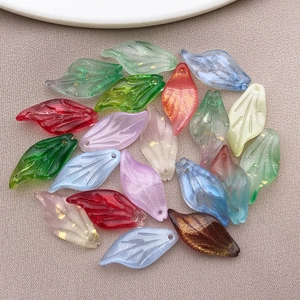 Close-up of leaf-shaped glass charms with gold foil flakes for DIY jewelry making