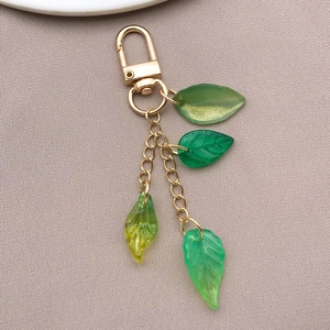 Detail of green resin leaf charms with gold plating chain and spring ring clasp