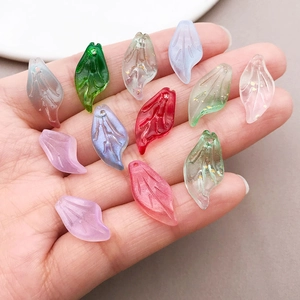Detailed close-up of mixed color glass leaf pendants for DIY jewelry making