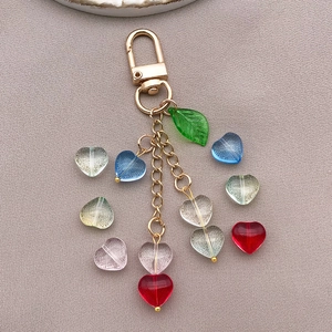 Macro detail of mixed candy color heart glass beads with gold keychain and leaf charm