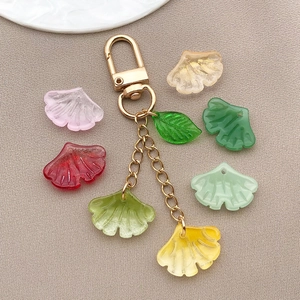 Macro shot of colorful translucent ginkgo leaf pendants with gold metal keychains