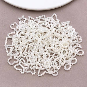 Detailed view of pearl white ABS heart and star charms for DIY phone case and nail art