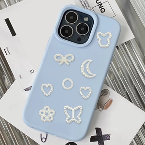 Light blue phone case decorated with white heart and butterfly pearl charms on aesthetic background