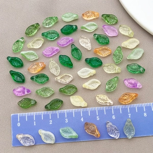 Macro detail of mixed color leaf-shaped glass beads with embossed veins for DIY jewelry