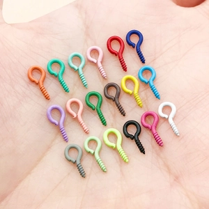 Close-up of small colorful painted eye pins for DIY jewelry making held in a palm