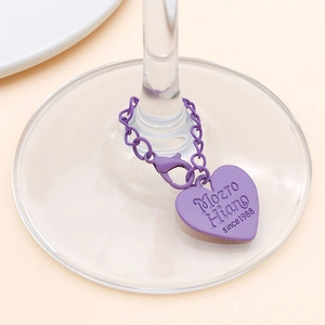 Close-up of purple heart pendant with lobster clasp attached to a glass stem