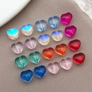 Close-up of colorful heart-shaped glass beads with hole for DIY jewelry making