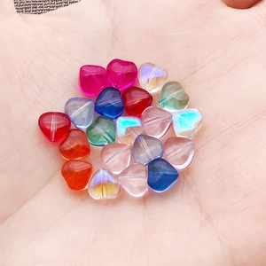 Macro shot of 6mm heart-shaped colored glass beads for DIY jewelry making in palm
