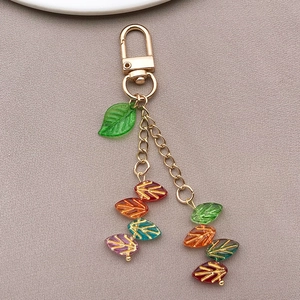 Dettaglio di perline colorate in vetro a foglia 11x7mm con venature dorate e ganci