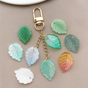 Detailed close-up of mixed color leaf charms with gold glitter and metal lobster clasp