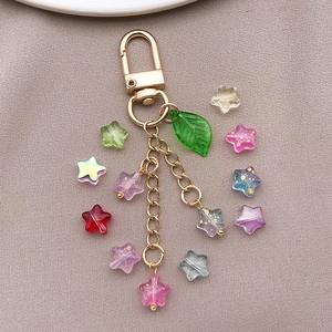 Detalle de llavero de estrella DIY con cuentas de vidrio coloridas y cadenas de oro