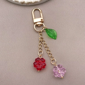 Detail of flower glass charms keychain with green leaf and colorful floral pendants