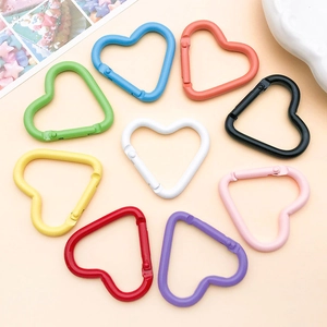 Nove moschettoni a cuore in alluminio colorato disposti in un cerchio piatto