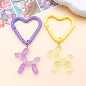 Dettaglio di moschettoni a cuore con pendenti a forma di cane palloncino colorati