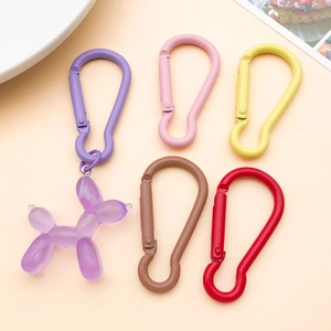Macro shot of macaron colored gourd clips with a purple translucent resin balloon dog pendant