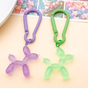 Detail of purple and green resin balloon dog charms with glitter finish and plastic hooks
