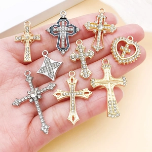 Detailed macro view of assorted gold and silver alloy cross charms with crystal accents