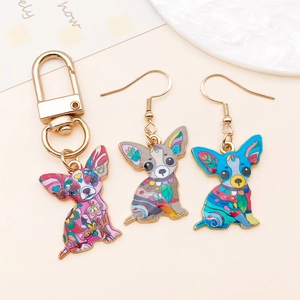 Detailed view of bohemian style enameled Chihuahua charms on gold keychain and earrings