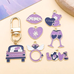 Detalle macro de colgantes de aleación de esmalte morado con labios XOXO y corazones